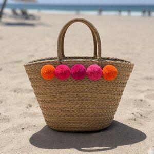 Straw Beach Tote with Vibrant Pom-Poms.